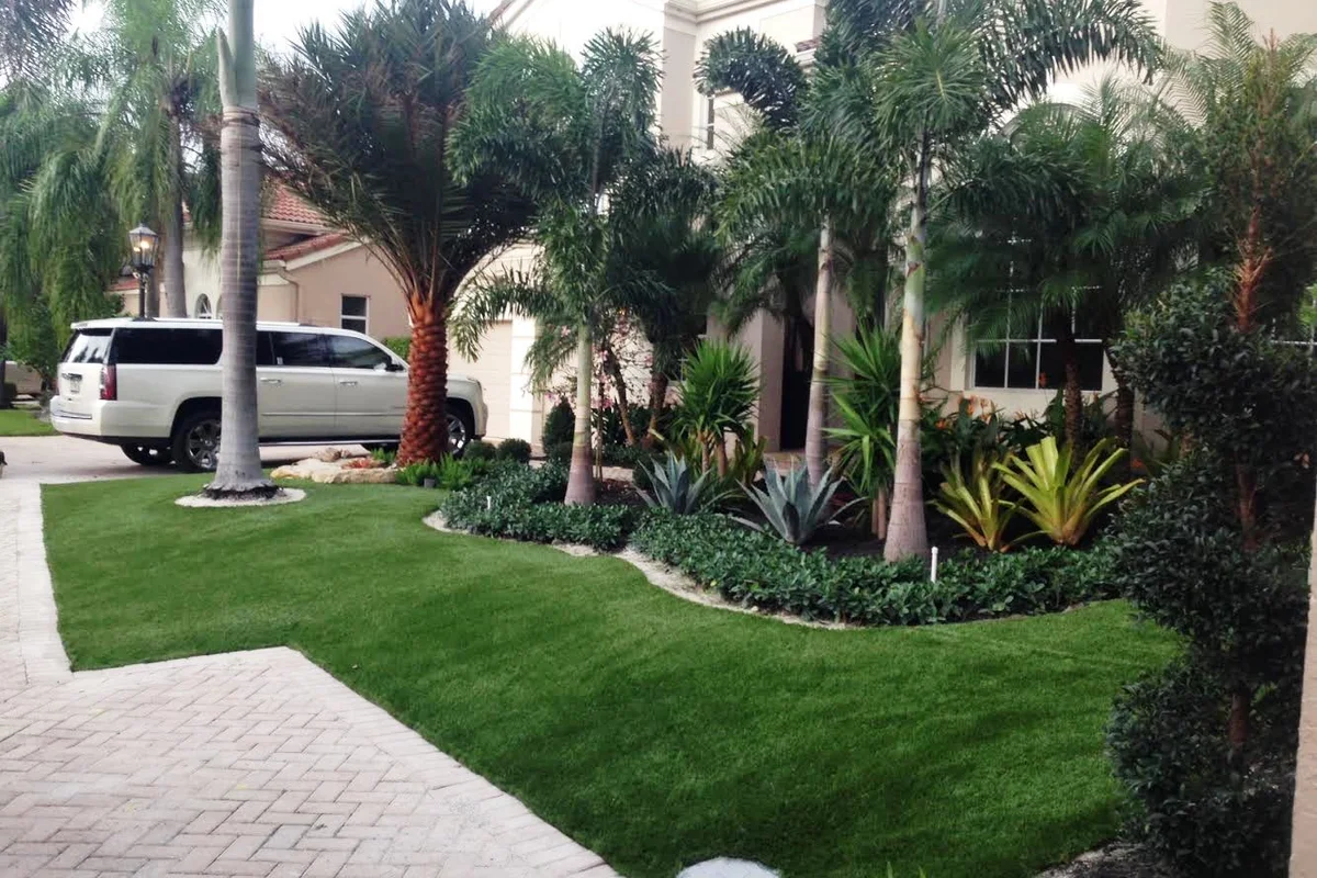 Florida front yard with artificial grass beside a paved driveway