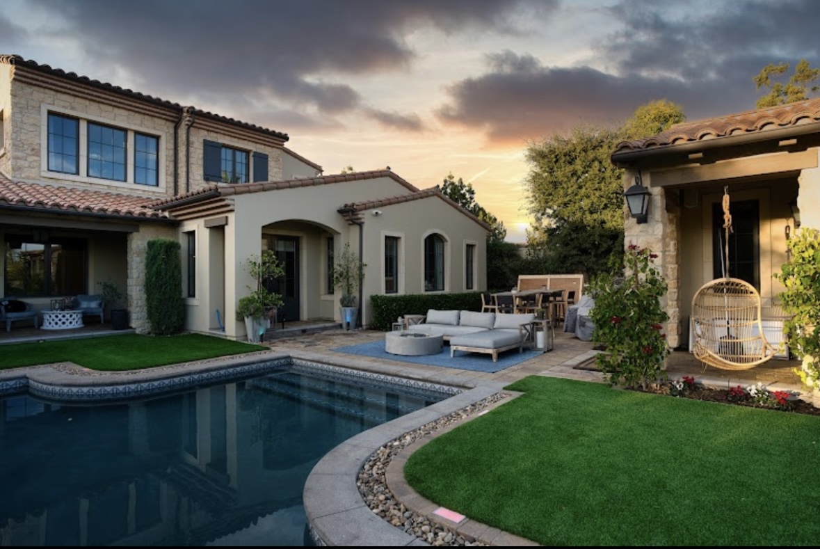 Broad finished artificial turf lawn outside a home at twilight