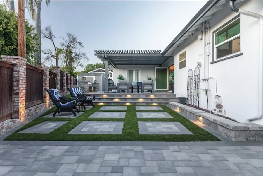 Concrete pavers and narrow turf strips in an open-air courtyard
