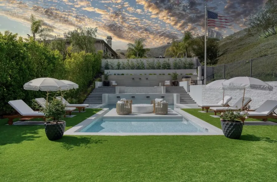 Curved turf edges around a swimming pool and planted backyard