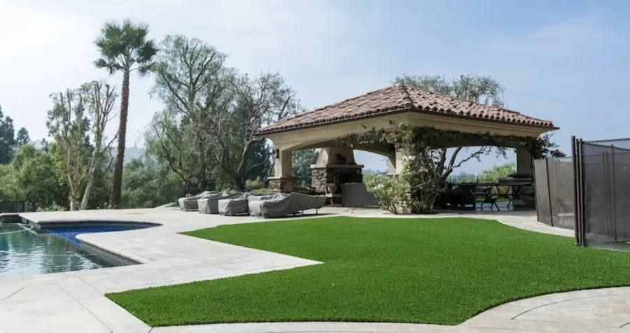 Bright turf lawn and a pale path in a walled courtyard