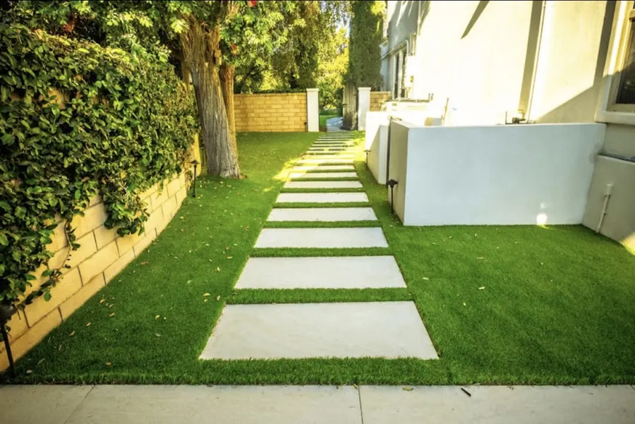 Finished TurfMastro side yard with square stepping stones set into turf
