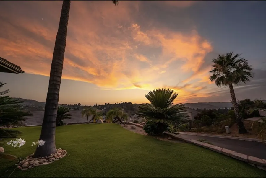 Turf lawn and low landscaping beneath a vivid evening sky